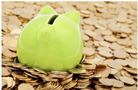 Sparschwein auf Goldmünzen – Sinnbild für Wirtschaftlichkeitsberechnungen